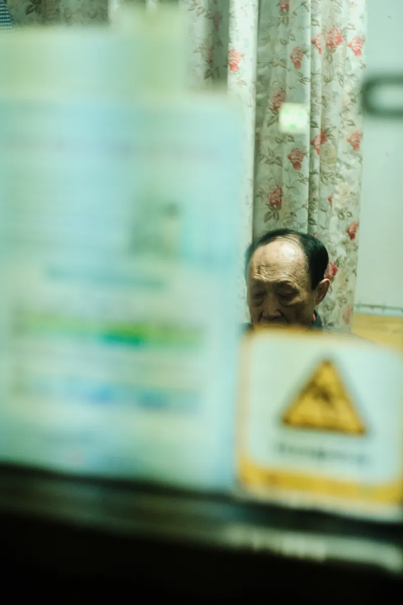 Blurred window with a man behind a yellow caution sign