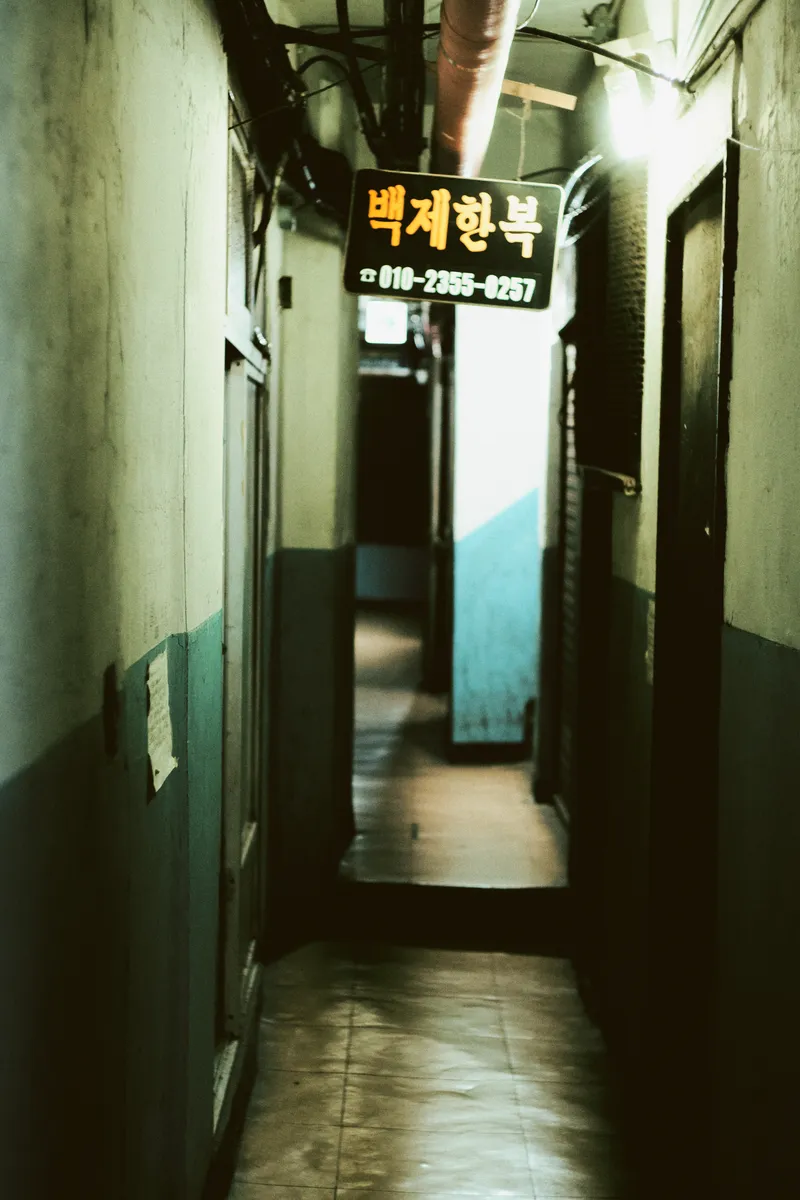 Narrow corridor with a yellow shop sign