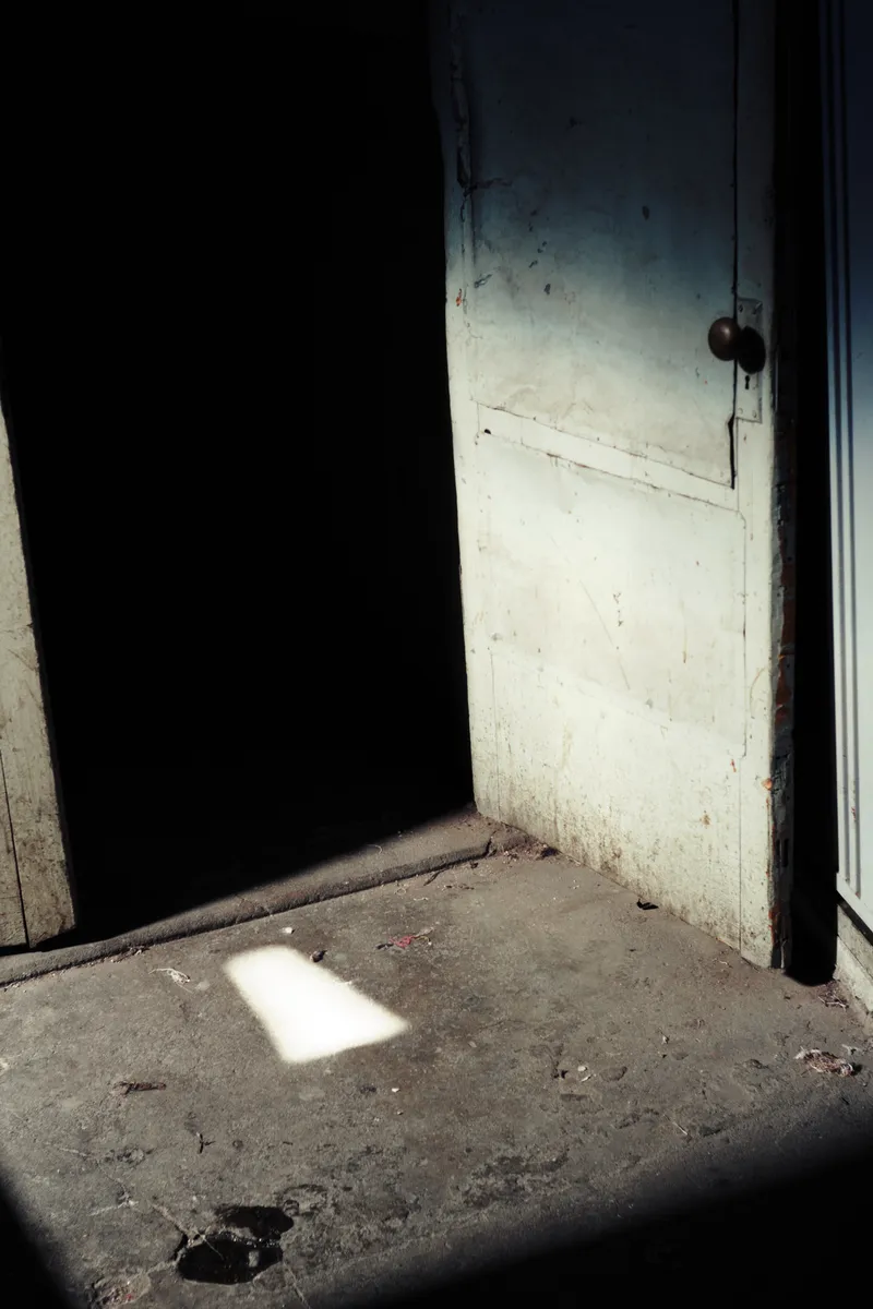 Dark doorway with a patch of light on the concrete floor