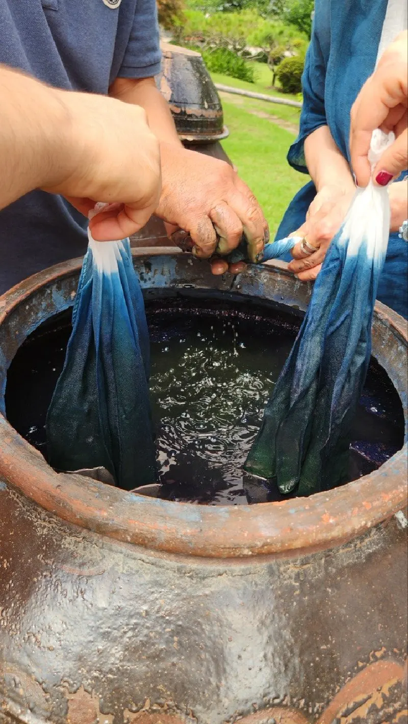 Cloth lifted out of the indigo jar, turning from green to blue
