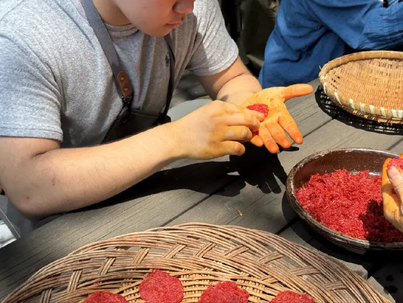 Pressing safflower petals into small cakes by hand