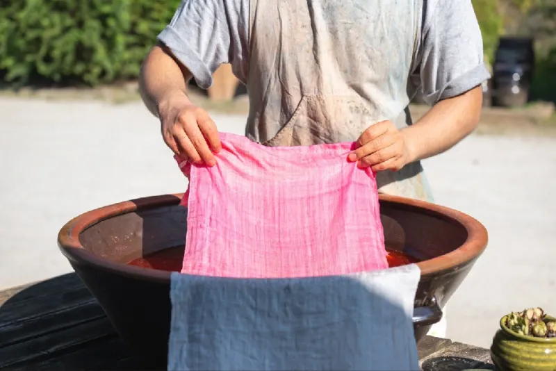 Pink cloth held up over blue cloth